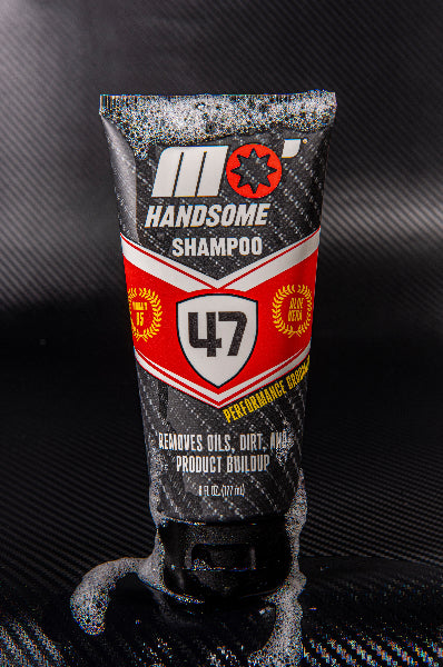 Mo’Handsome tube featuring bold red Ferrari-style design—surrounded by bubbles on a sleek carbon fiber backdrop.