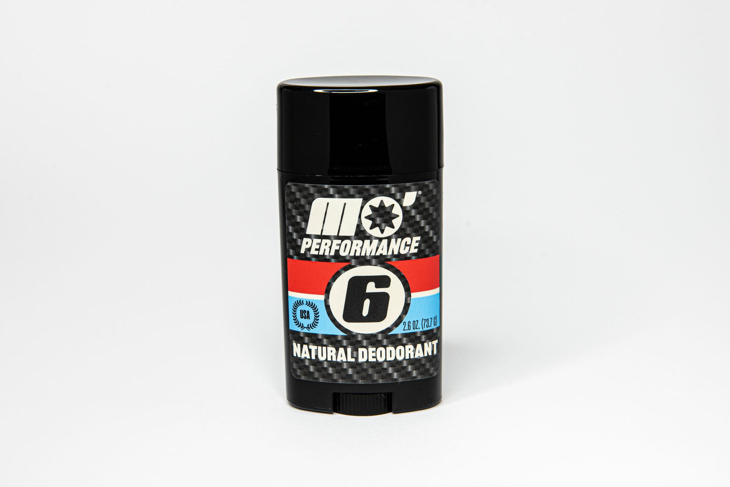 Mo’Handsome Mo’ Performance natural deodorant standing upright with No. 6 roundel and carbon fiber look—bold design, all-day freshness.