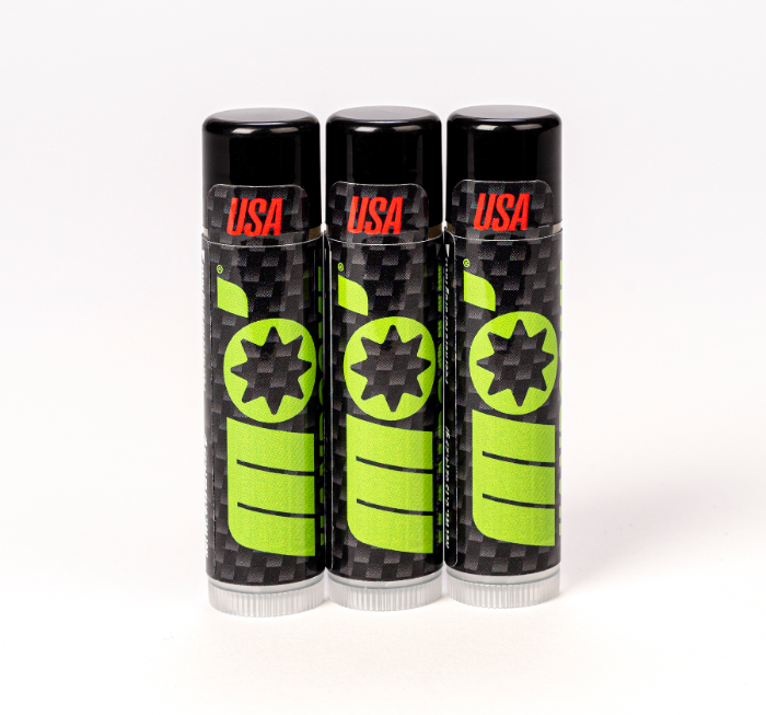 Close-up of Mo’Handsome triple pack all natural, mint lip balm in sleek carbon fiber packaging—premium grooming for men.