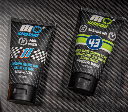 Two tubes of 'Handsome' grooming products on a carbon fiber surface