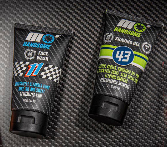 Two tubes of 'Handsome' grooming products on a carbon fiber surface