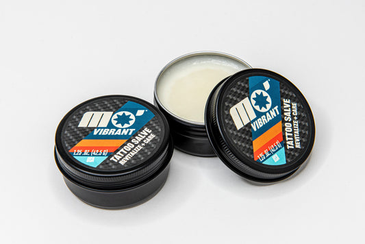 Mo’Handsome tattoo salve shown open with balm texture visible—formulated for tattoo aftercare and skin repair.